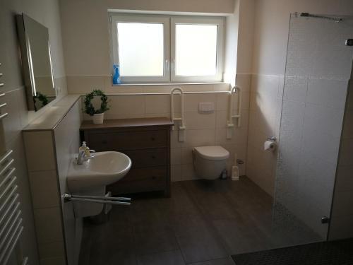 a bathroom with a sink and a toilet and a window at Nike -barrierearm- in Burg auf Fehmarn