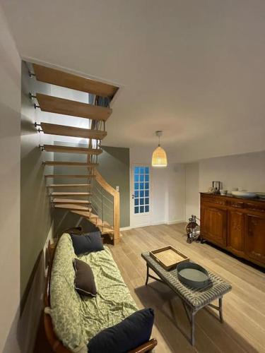 un salon avec un escalier et un canapé dans l'établissement Maison familiale 12p à pied plages de Port-Blanc, à Penvénan