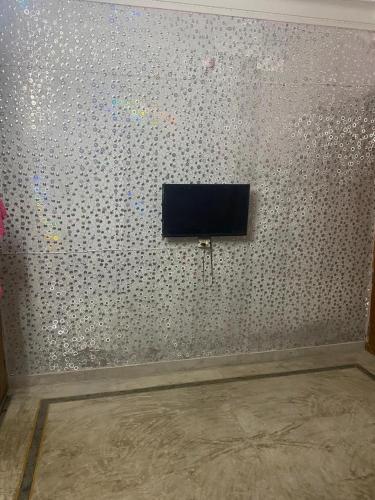 una habitación con una pared y TV. en Inpalace guest house en Gwalior