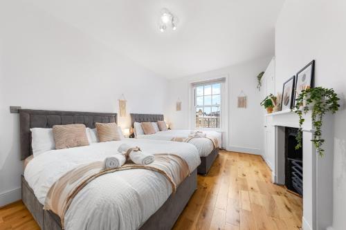 2 Betten in einem Schlafzimmer mit Kamin in der Unterkunft Stunning apartment in Kings Cross sleeps 10 in London