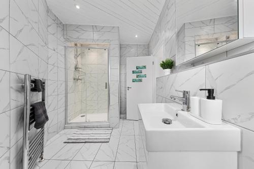a white bathroom with a sink and a shower at Stunning apartment in Kings Cross sleeps 10 in London