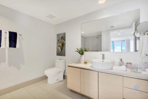uma casa de banho branca com um lavatório e um WC em Amazing Pool - Apartment with Balcony and Gym em Hallandale Beach