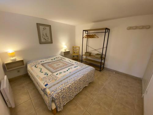 1 dormitorio con cama y estante en L’Olivier en Grignan