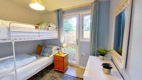 Un dormitorio con dos literas y una ventana. en 59 Trevithick Court, Tolroy Manor, en Hayle