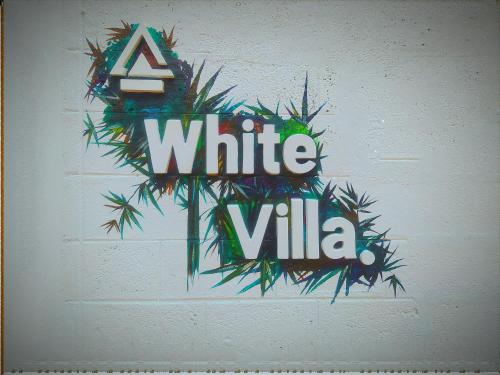 un cartel que dice Villa blanca en una pared en White Villa Goyambokka en Tangalle