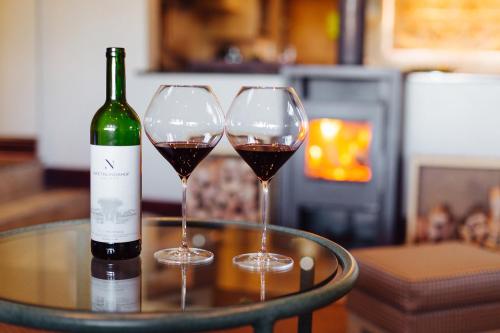 due bicchieri di vino su un tavolo con una bottiglia di vino di Staymore Guesthouse a Stellenbosch
