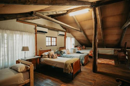 a bedroom with three beds in a room with wooden ceilings at Mont Rouge Cottage in Tulbagh