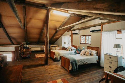 a bedroom with two beds in a room with wooden floors at Mont Rouge Cottage in Tulbagh