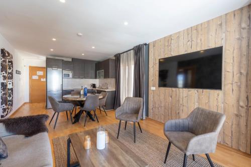 a living room with a table and chairs and a television at BiBo Suites Sierra Nevada in Sierra Nevada