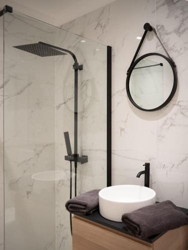 une salle de bain avec un lavabo et une douche avec un miroir dans l'établissement Le Bougainvillier-Jacuzzi Jardin Clim Wifi Parking, à Marseille
