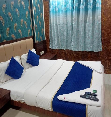 a bedroom with a bed with blue pillows at HOTEL MANTRA NX in Mumbai