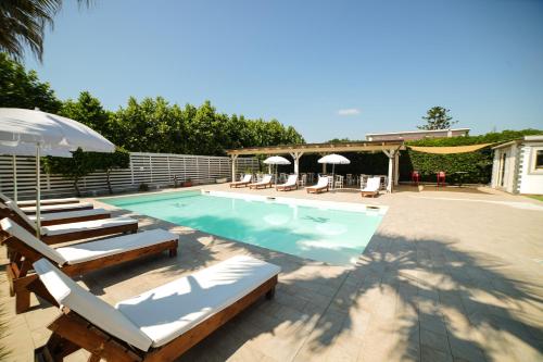una piscina con tumbonas y sombrilla en Villa Miramare, en Pontecagnano Faiano