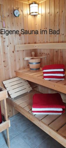 a sauna with two red and white towels on a shelf at Wikingerland Typ 2 Obergeschoss in Langballig