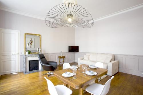 un salon avec une table et des chaises dans l'établissement Habitat Parisien - 1BR-1BA - Galeries Lafayette, à Paris