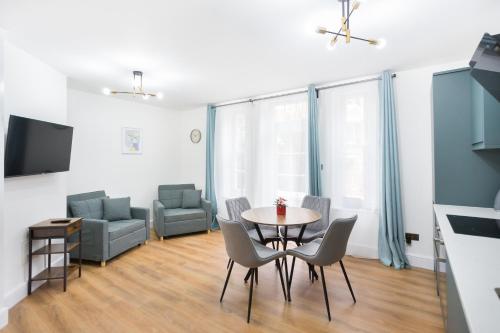 - un salon avec une table, des chaises et un canapé dans l'établissement City Centre One Bedroom Apartment Next to Station, Newly Renovated, à Londres