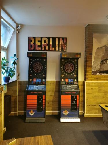 a room with two video game machines on the wall at 1 Zimmer Apartment mit bis zu 4 Schlafplätzen, separate Küche und Bad mit Garten und Parkplatz in Berlin