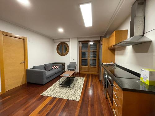 cocina y sala de estar con sofá en Apartamento con piscina VIESQUES, en Gijón