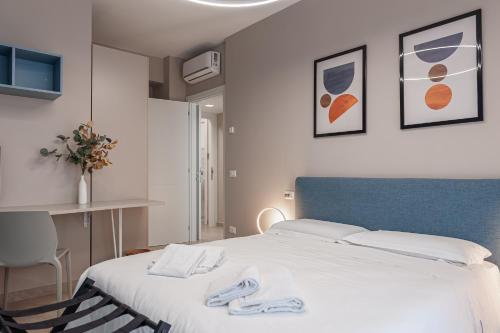 een slaapkamer met een bed met witte lakens en een blauw hoofdeinde bij La Casa di Duccio in Perugia