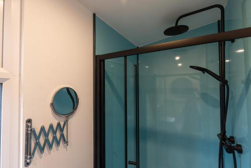 uma cabina de duche em vidro na casa de banho com um espelho em The Piggery at Little Pig em Bude