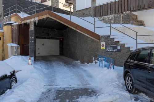 a car parked in front of a garage covered in snow at BiBo Suites Sierra Nevada in Sierra Nevada