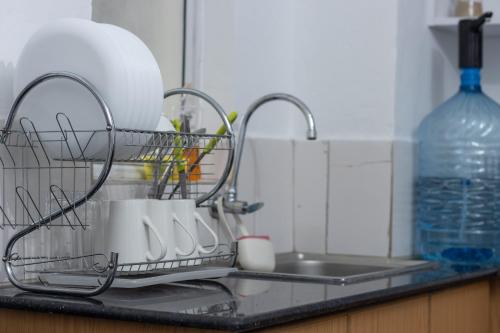a dish drying rack with cups and a sink at Anga Nest a chic One-Bedroom Ngong Road in Nairobi