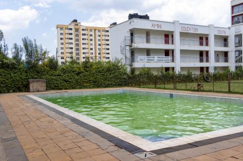 a swimming pool in front of a building at Anga Nest a chic One-Bedroom Ngong Road in Nairobi