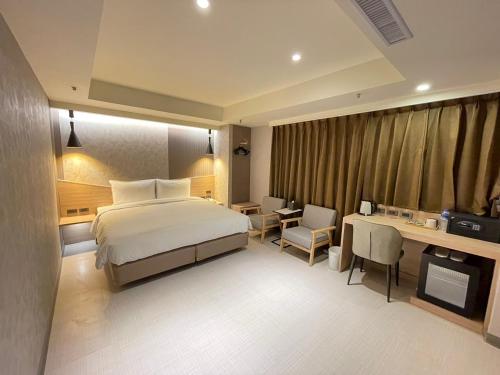 Habitación de hotel con cama y escritorio en 新仕飯店-New City Hotel en Taipéi