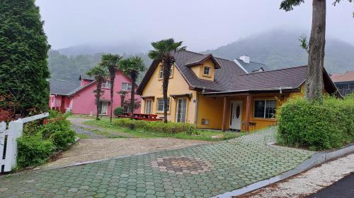 a group of houses with palm trees on a street at Santa Monica Pension in Kokhae