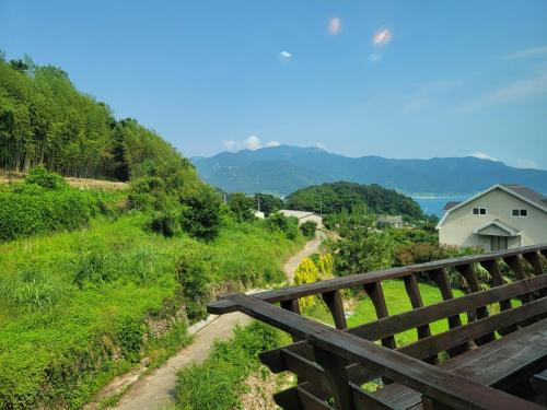 a wooden fence on a hill with a house at Santa Monica Pension in Kokhae