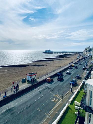 a road with cars on it next to the beach at East Beach Hotel in Eastbourne
