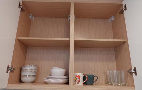 a wooden shelf with plates and cups on it at Oceanfront Luxury Condo in Pattaya with Private Beach and Inifinity Pool - NOT A HOTEL 30 Day Stay Minimum in Pattaya North
