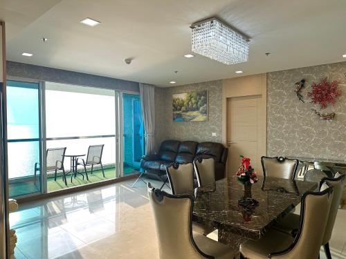 a dining room with a table and a couch at Oceanfront Luxury Condo in Pattaya with Private Beach and Inifinity Pool - NOT A HOTEL 30 Day Stay Minimum in Pattaya North