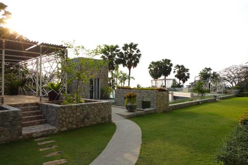 a garden with a stone wall and a lawn at Oceanfront Luxury Condo in Pattaya with Private Beach and Inifinity Pool - NOT A HOTEL 30 Day Stay Minimum in Pattaya North