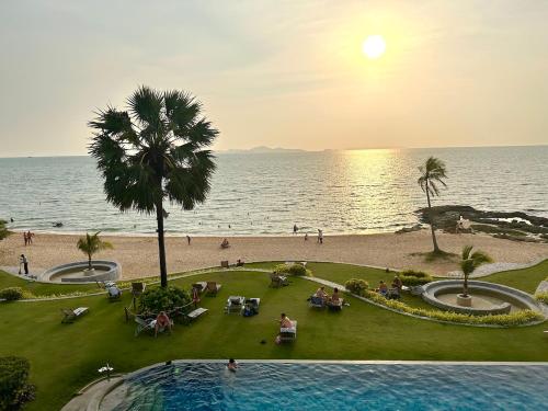 a view of the beach and the ocean at sunset at Oceanfront Luxury Condo in Pattaya with Private Beach and Inifinity Pool - NOT A HOTEL 30 Day Stay Minimum in Pattaya North