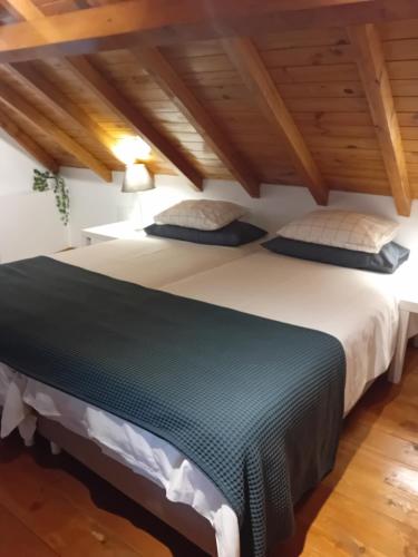 アルコシェテにあるCasa do Tejo de Alcocheteの木製の天井の客室で、ベッドルーム1室(大型ベッド1台付)