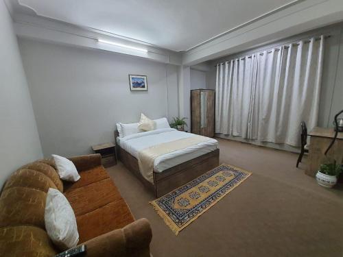 sala de estar con cama y sofá en Payong House, en Gangtok