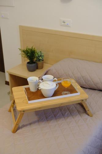 a coffee table with bowls and cups on a bed at Hotel Milano in Tolentino