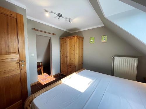 ein Schlafzimmer mit einem großen weißen Bett im Dachgeschoss in der Unterkunft Wattblick in Dagebüll