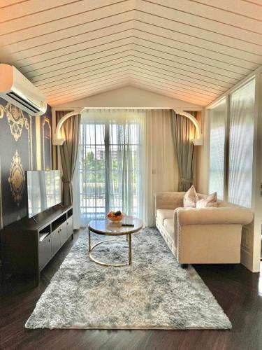a living room with a couch and a table at Grand Florida Beachfront Resort Jomtien Pattaya in Na Jomtien