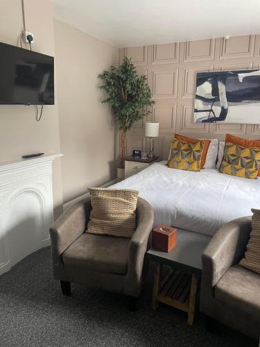 a bedroom with a bed and a couch and a chair at The Crown Inn - Rooms in Keynsham