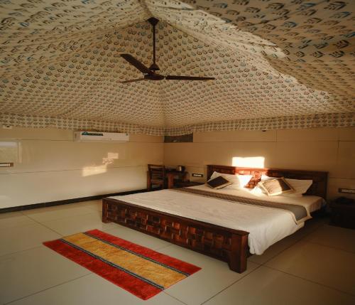 a bedroom with a bed and a ceiling with a fan at Bharat Lake view Resort- Pure Veg Restaurant in Udaipur