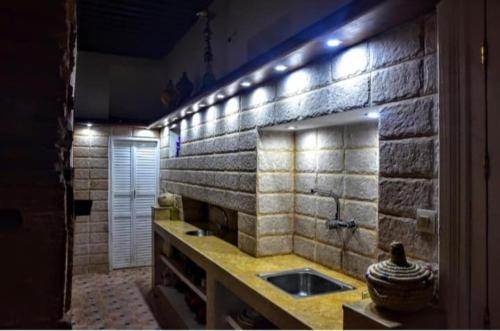a bathroom with a sink and a stone wall at Riad Razoli Sidi Daoui in Rabat