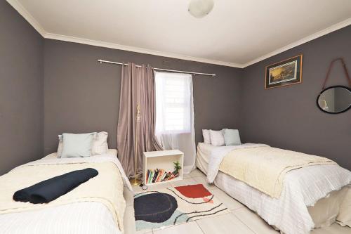 a bedroom with two beds and a window at Mikasa Sukasa in Cape Town