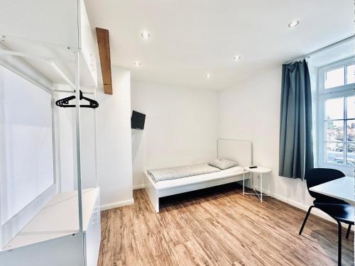 um quarto branco com um banco e uma janela em Monteurzimmer - Worker's accommodation - ZIMMERzuVERMIETEN Oensingen em Oensingen