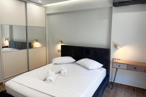 1 dormitorio con 1 cama blanca grande y toallas. en Kinfeels' junior suite (A1), en Larisa