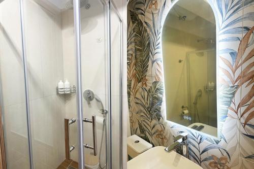 y baño con ducha, lavabo y espejo. en Kinfeels' junior suite (A1), en Larisa