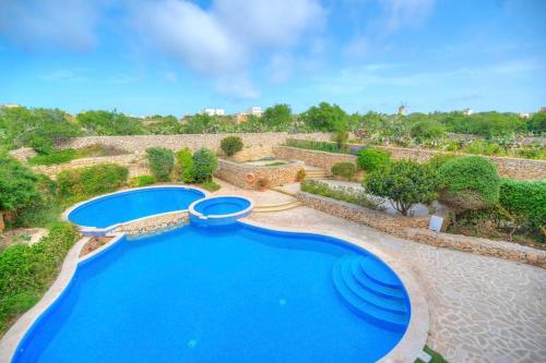 einen Blick über einen Pool im Hof in der Unterkunft A lovely 3BR spacious home with Access to POOL by 360 Estates in Qala