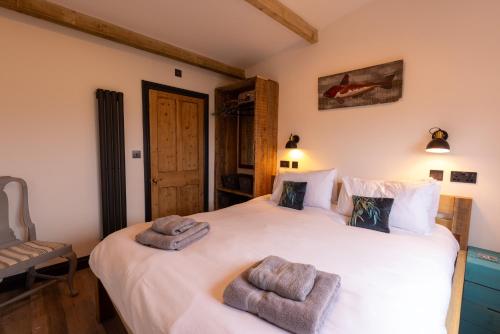 a bedroom with two beds with towels on them at The Piggery at Little Pig in Bude