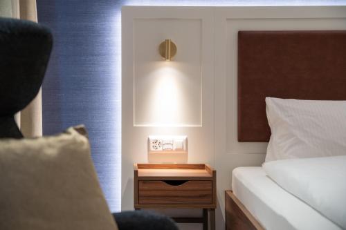 a bedroom with a bed and a nightstand with a lamp at Hotel Du Nord in Interlaken