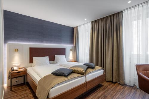 a bedroom with a large bed with two pillows on it at Hotel Du Nord in Interlaken